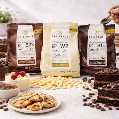 Callebaut Kuvertüre Callets 3x400g mit Zartbitter-, Milch- und weißer Schokolade, umgeben von Cookies, Kuchen, Schoko-Callets und einer Hand, die Schokolade über Kuchen gießt.