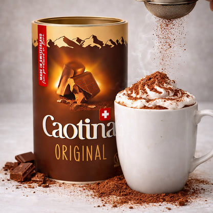 Caotina Original Kakaopulver neben einer Tasse Trinkschokolade mit Sahne und Kakaopulver bestreut.