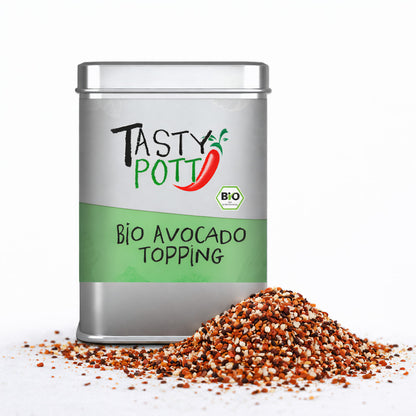 Tasty Pott Bio Avocado Topping Dose mit grünem Etikett, daneben ein Haufen bunter Gewürzmischung auf weißem Hintergrund.