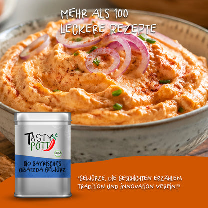 Schale mit cremigem Obatzda-Dip, garniert mit roten Zwiebeln und Kräutern, vorne eine Dose Tasty Pott Bio Bayrisches Obatzda Gewürz.