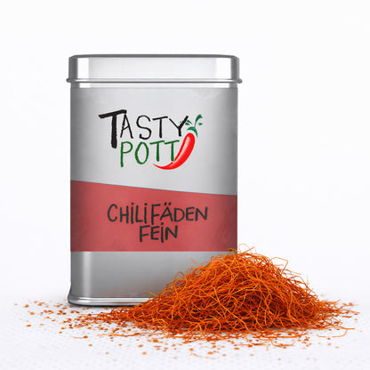 Tasty Pott Dose mit Chilifäden fein, im Vordergrund ein Haufen feiner, roter Chilifäden auf weißem Untergrund.