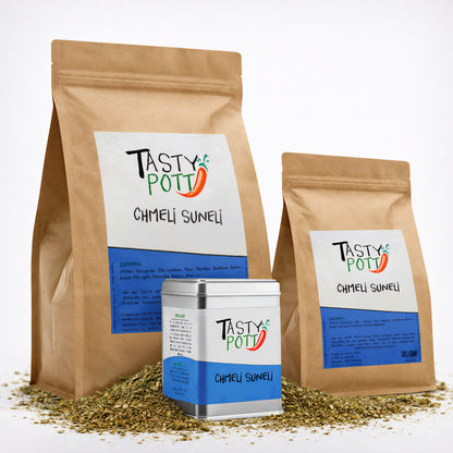 Drei Tasty Pott Chmeli Suneli Gewürzmischung Verpackungen, zwei braune Beutel und eine silberne Dose, stehen auf einer Schicht grober Gewürze.
