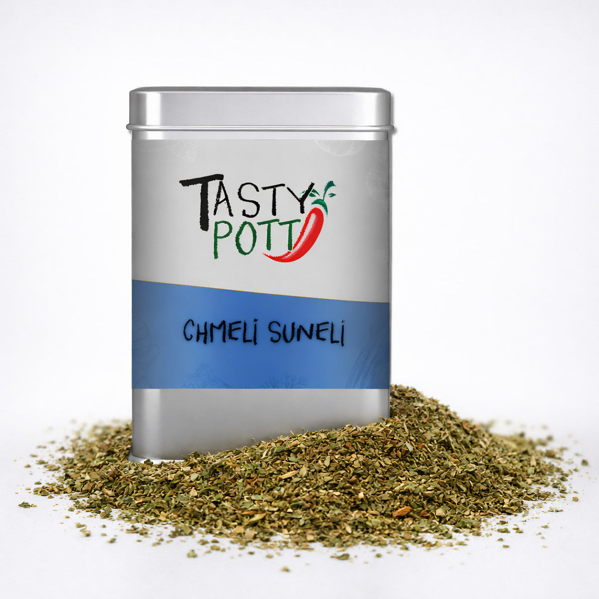 Tasty Pott Chmeli Suneli Gewürzmischung in silberner Dose, umgeben von einem Haufen grüner, grober Kräuter.