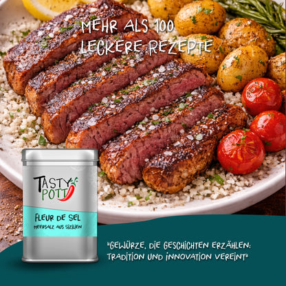 Angeschnittenes Steak mit Fleur de Sel Meersalz von Tasty Pott, angerichtet mit Kartoffeln und Tomaten auf einem Teller.