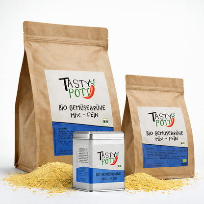 Zwei braune Nachfüllbeutel und eine Metalldose Tasty Pott Bio Gemüsebrühe, umgeben von feinem gemüsebrühe-Pulver.