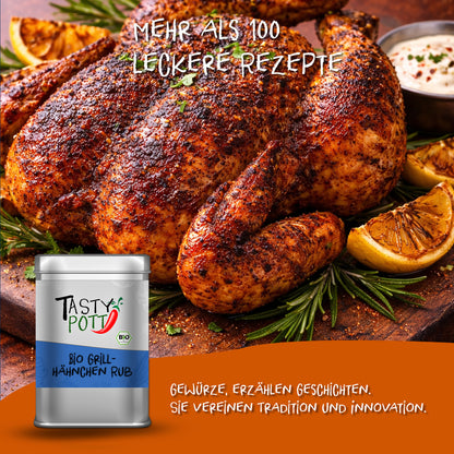 Gegrilltes ganzes Hähnchen mit Tasty Pott Grillhähnchen Rub, angerichtet mit Zitronenspalten und Kräutern, im Vordergrund die silberne Gewürzdose.
