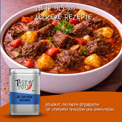 Schale mit klassischem Gulaschgericht, darin Fleischstücke, Kartoffeln und Paprika, vorne links die Tasty Pott Gulaschgewürz-Dose auf orangefarbenem Streifen.