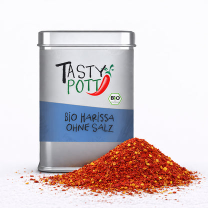 Tasty Pott Bio Harissa Gewürzmischung ohne Salz in silberner 100g Dose, davor ein Haufen rotes Harissa-Gewürzpulver.