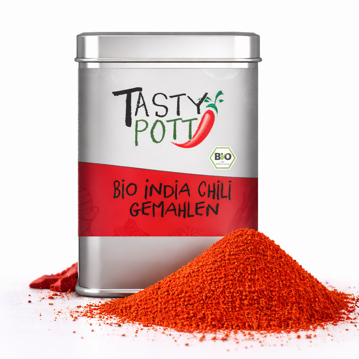 Tasty Pott Bio India Chili Pulver in silberner Dose mit rotem Etikett, daneben ein Haufen leuchtend rotes chilipulver auf weißem Hintergrund.