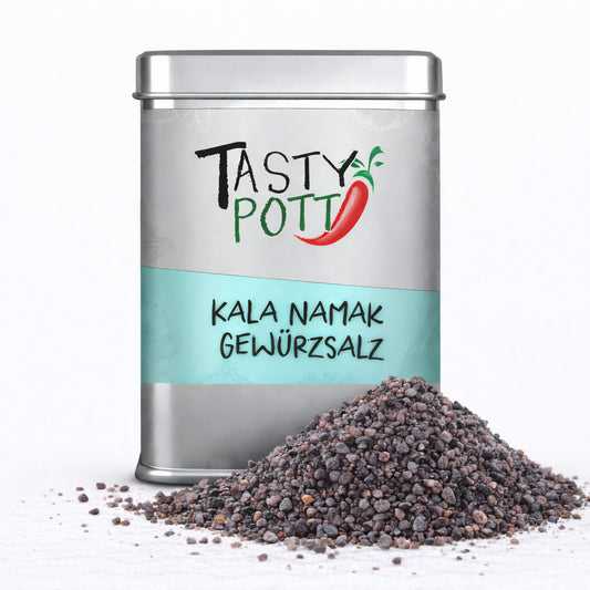 Tasty Pott Kala Namak Salz in silberner Dose mit türkisfarbenem Etikett, davor ein Haufen grobkörniges indisches Schwarzsalz auf weißem Untergrund.