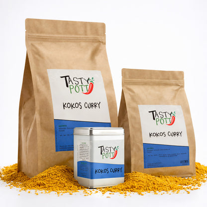 Drei Tasty Pott Kokos Curry Gewürz Nachfüllbeutel und eine Dose stehen auf einem Haufen gelbem Currypulver.