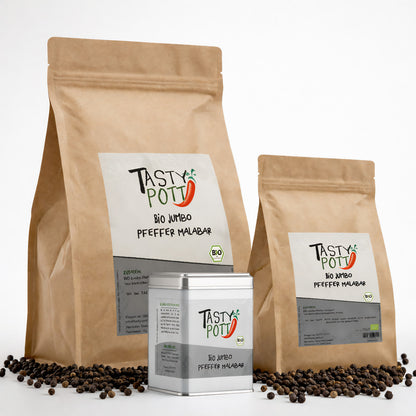 Drei Tasty Pott Bio Jumbo Malabar Pfeffer Nachfüllbeutel und eine Pfefferdose mit sichtbaren schwarzen Pfefferkörnern auf weißem Hintergrund.