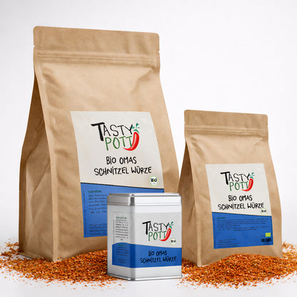 Drei Beutel und eine Dose Bio Omas Schnitzel Gewürzmischung von Tasty Pott auf verstreutem Gewürz, frontal nebeneinander angeordnet.