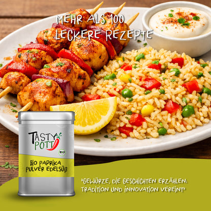 Tasty Pott Dose Bio Paprika Pulver edelsüß vor Teller mit Reis, Gemüse und Grillspießen, angerichtet mit Zitronenspalte und Dip.