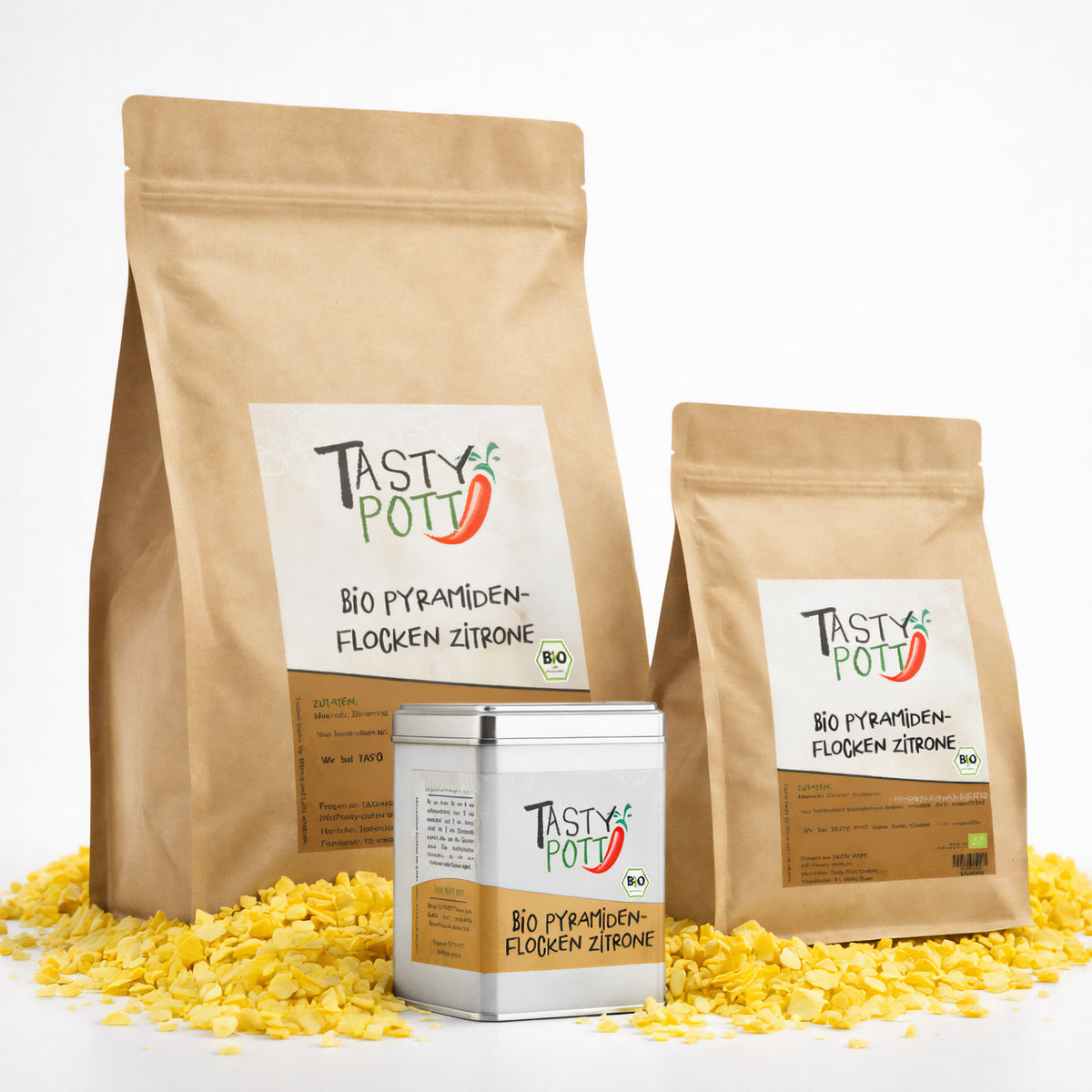 Drei Tasty Pott Nachfüllbeutel und eine Dose Bio Pyramidenflocken Zitrone stehen auf gelben Zitronensalzflocken.
