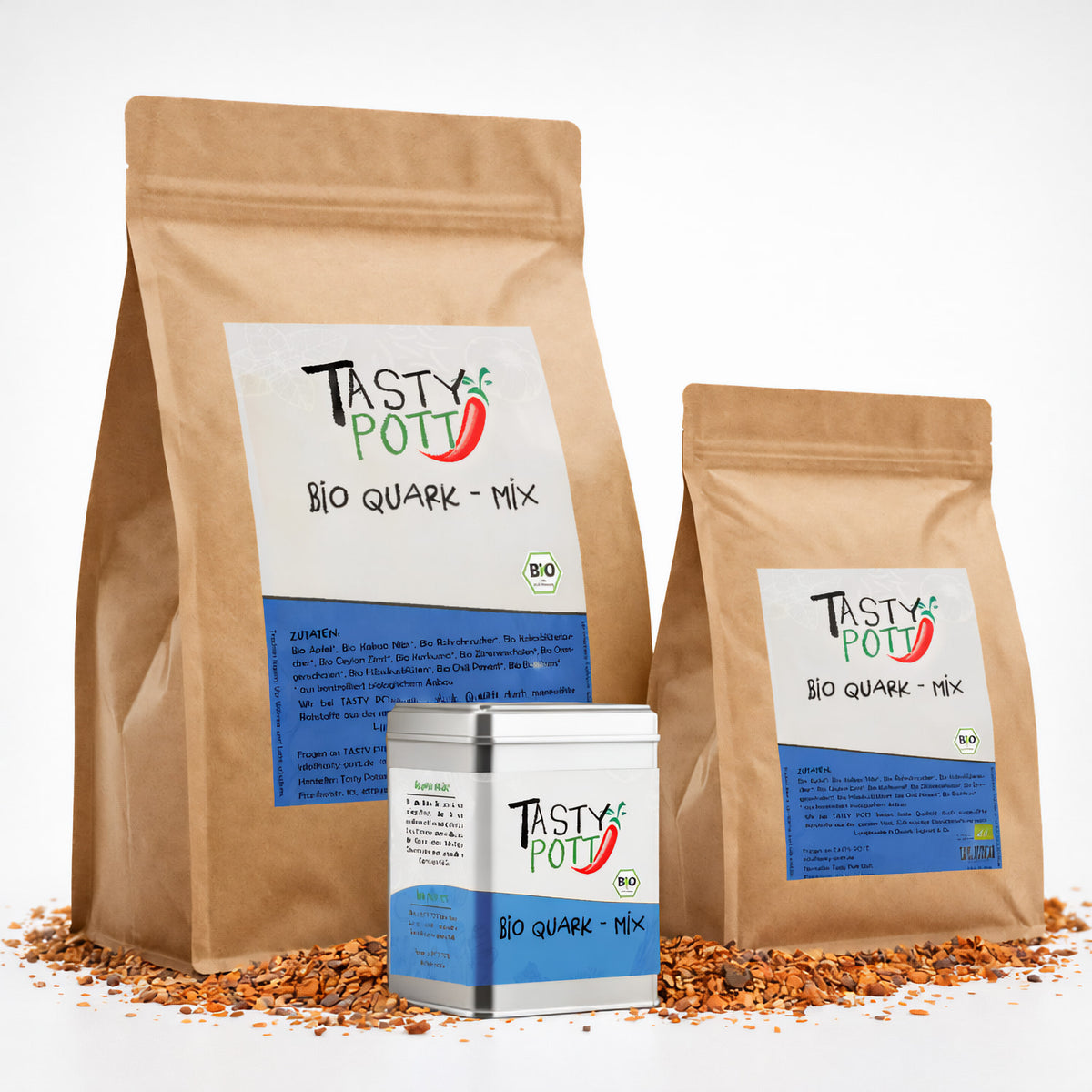 Drei Tasty Pott Bio Quark Gewürzmischung Verpackungen, zwei braune Nachfüllbeutel und eine Metalldose, stehen auf verstreuten Gewürzen.
