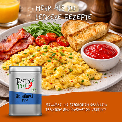 Tasty Pott Bio Rührei Mix Dose vor einem Teller mit Rührei, Toast, Tomaten, Speck, Rucola und Dip, als Frühstück angerichtet.