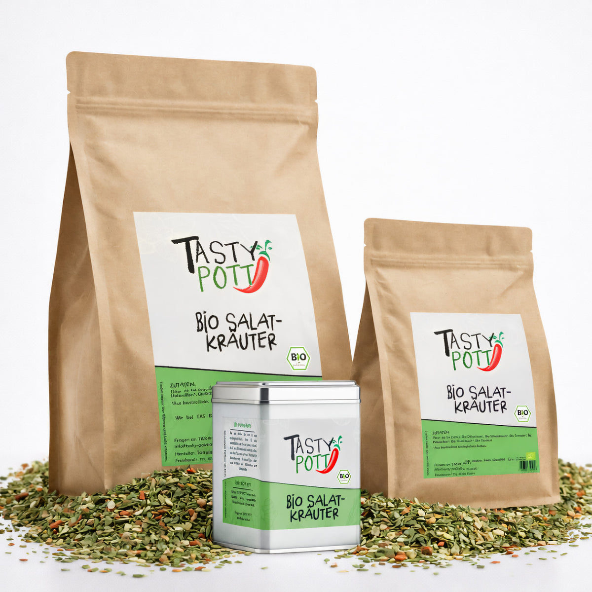 Drei Tasty Pott Salatkräuter Nachfüllbeutel und eine Gewürzdose stehen auf einem Haufen getrockneter Kräuter.