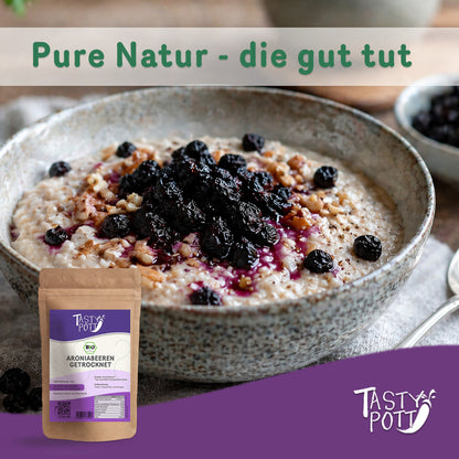 Schale Porridge mit getrockneten Aroniabeeren von Tasty Pott als Topping, im Vordergrund ein Beutel getrocknete Beeren.