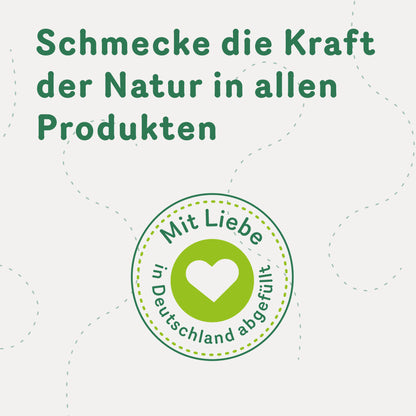 Siegel mit Herz und Text 'Mit Liebe in Deutschland abgefüllt', darüber Slogan zur natürlichen Kraft in allen Tasty Pott Superfood Produkten.