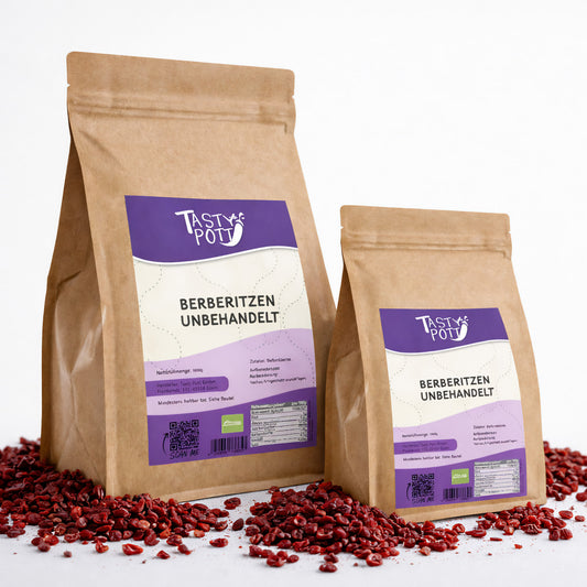 Zwei braune Beutel Tasty Pott Berberitzen getrocknet, stehend auf verstreuten getrockneten beeren, Vorderseite mit Etikett sichtbar.