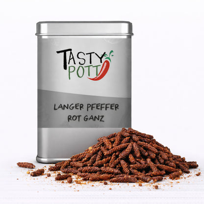 Vorderansicht einer silbernen Tasty Pott Dose mit der Aufschrift langer pfeffer rot ganz, davor ein Haufen ganzer roter Stangenpfeffer auf weißem Untergrund.