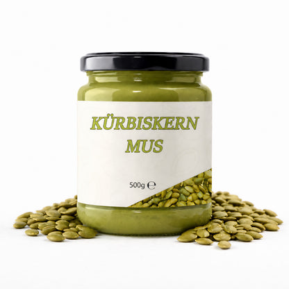 Glas Kürbiskernmus 500g von Mynatura als aromatischer Brotaufstrich, umgeben von Kürbiskernen, frontal fotografiert auf weißem Hintergrund.