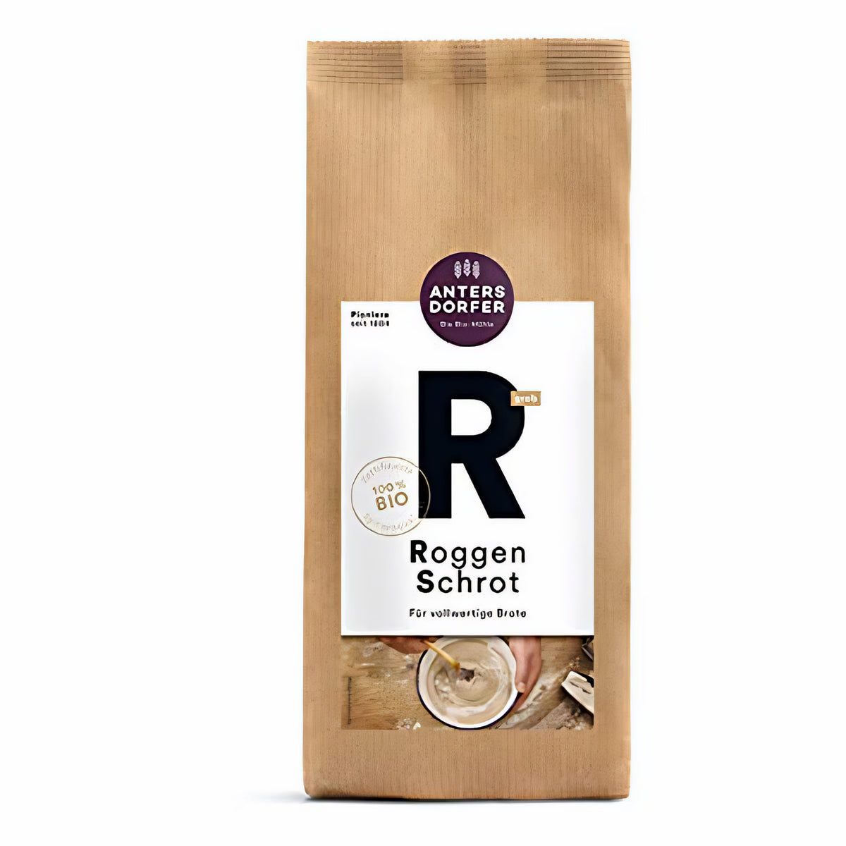Braune Papiertüte Antersdorfer Roggen Schrot 750g mit großem R auf weißem Etikett und Blick auf eine Schüssel mit Teig am unteren Rand.
