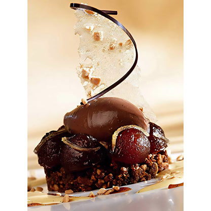 Schokoladen-Dessert mit callebaut mousse, glasierten Früchten, Nüssen und dekorativem Schokoladenstück auf einem Teller angerichtet.