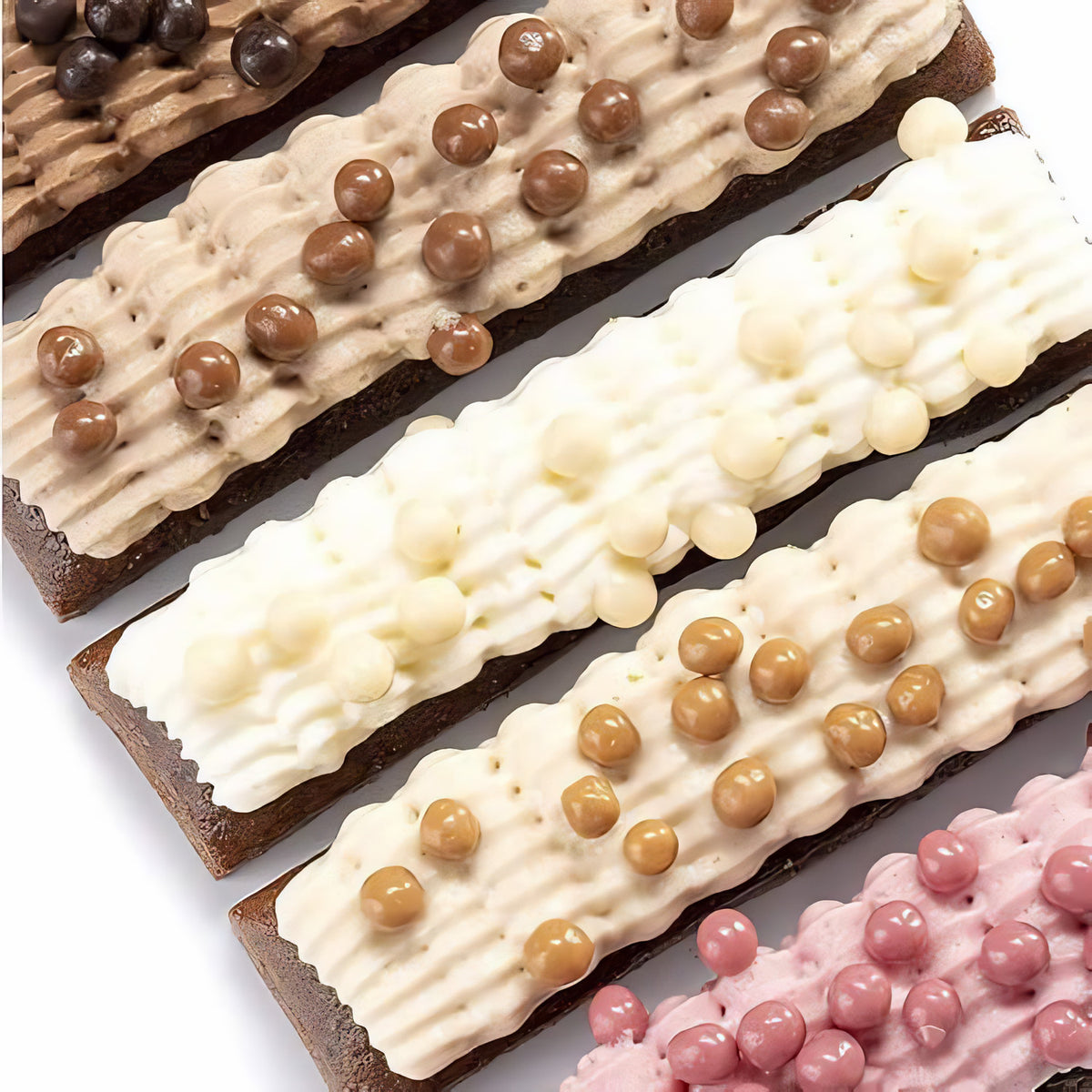 Schokoladenriegel mit Creme und Mona Lisa Crispearls Salted Caramel sowie anderen Sorten als Dessertdekoration aufgetragen.