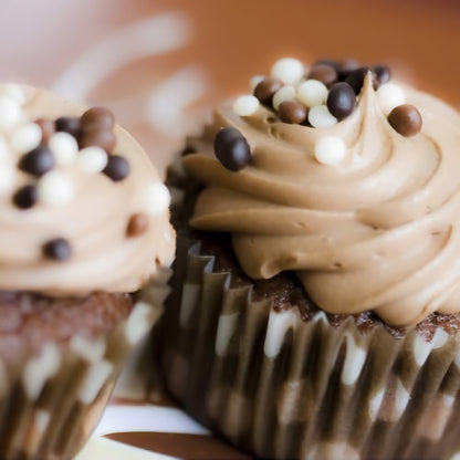 Zwei Cupcakes mit Schokoladencreme und Mona Lisa Crispearls als Dessertdekoration auf der Creme.