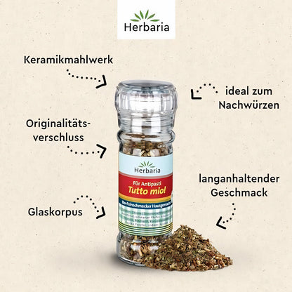 Herbaria Tutto mio! Gewürzmischung in einer Glasmühle mit Keramikmahlwerk, Originalitätsverschluss und losem Gewürzhaufen, beschriftet mit Anwendungshinweisen.