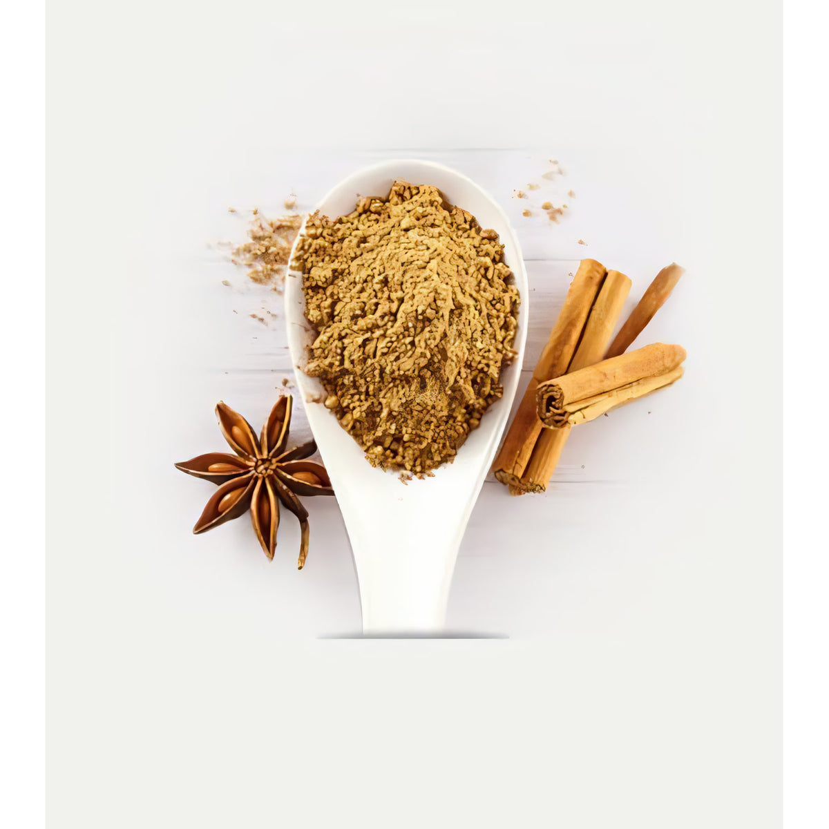 Nahaufnahme eines Löffels mit klassischem Porridge-Gewürz von lebensbaum, daneben Zimtstangen und Sternanis als Frühstücksgewürz.