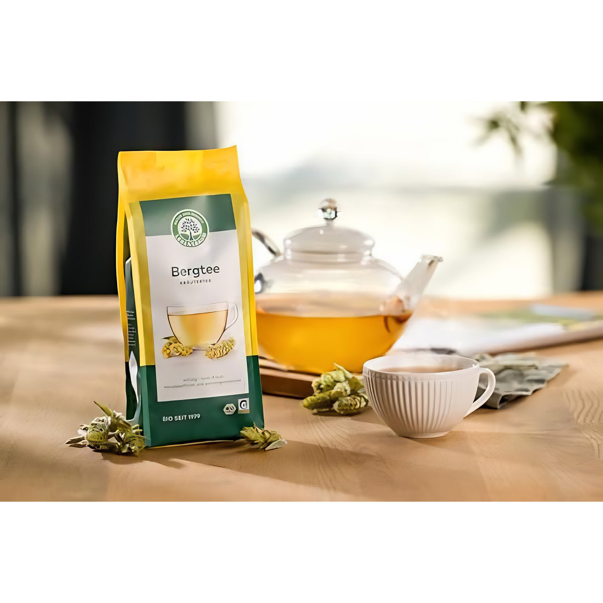 Lebensbaum Bergtee, loser Kräutertee im Beutel, neben einer Teekanne und einer Tasse auf einem Holztisch arrangiert.