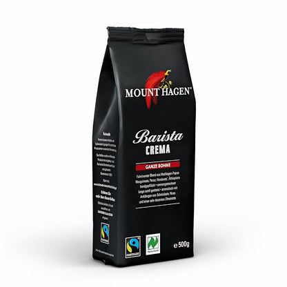 Packung Mount Hagen Barista Crema ganze Bohne 500g mit Fairtrade- und Naturland-Siegel, stehend auf weißem Hintergrund.