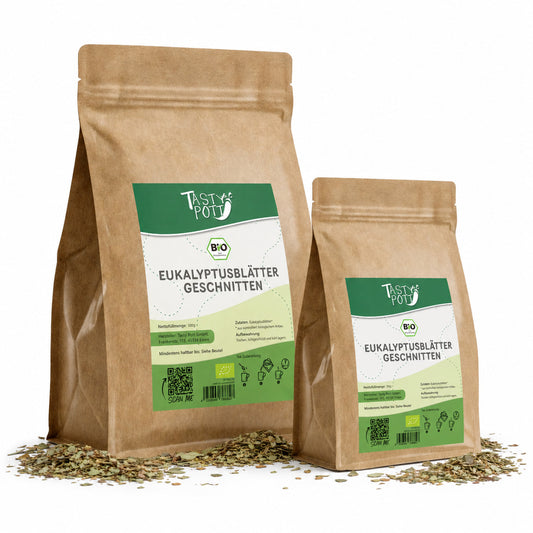 Zwei Beutel tasty pott Bio Eukalyptusblätter getrocknet und geschnitten, stehend auf verstreuten eukalyptusblättern, Vorderseiten mit Etikett sichtbar.