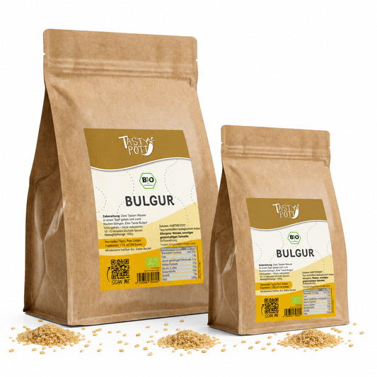 Zwei Beutel Tasty Pott Bulgur aus Hartweizen stehen nebeneinander, davor liegt etwas Bulgur lose auf weißem Untergrund.
