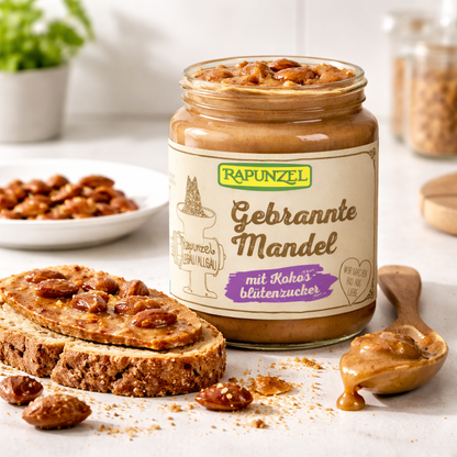 Bio gebrannter Mandel-Aufstrich mit Kokosblütenzucker von Rapunzel, in 250g Glas, mit Mandel- und Kokosnuss-Details sichtbar