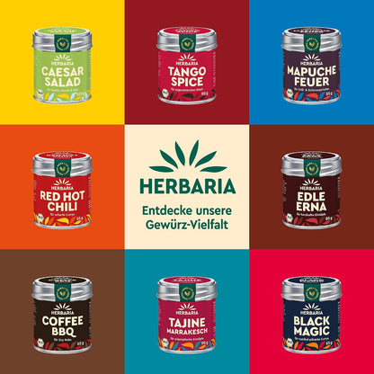 Bunte Übersicht verschiedener Herbaria Gewürzdosen, darunter Chili con Carlos, auf farbigem Hintergrund angeordnet.
