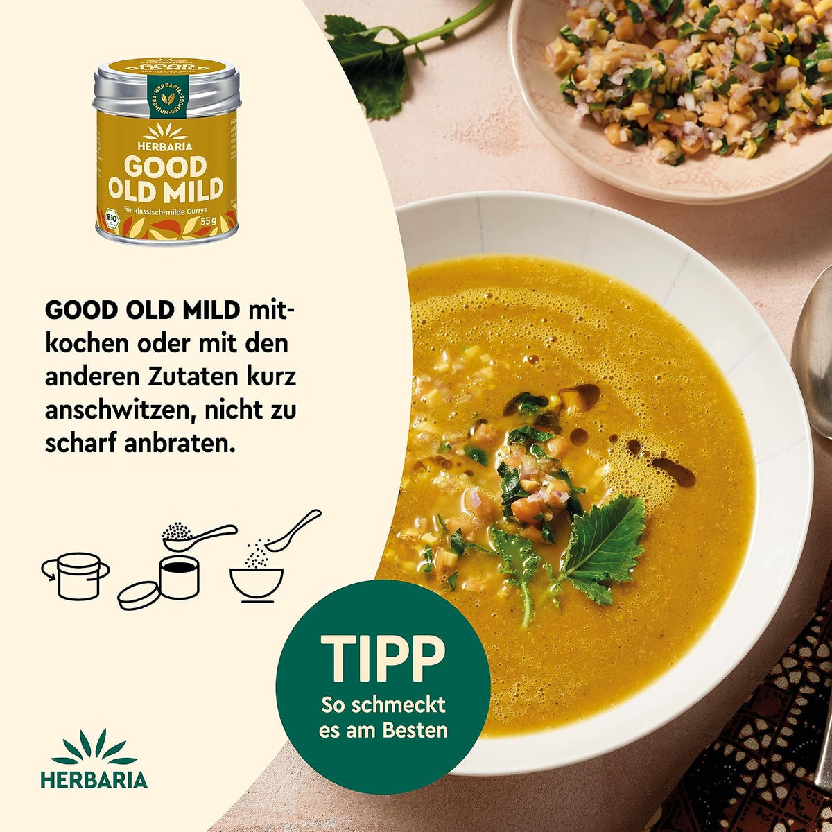 Teller mit gelber Currysuppe, daneben Schälchen mit gehackten Zutaten und Herbaria Good Old Mild Curry Dose, Tipp zur Verwendung eingeblendet.