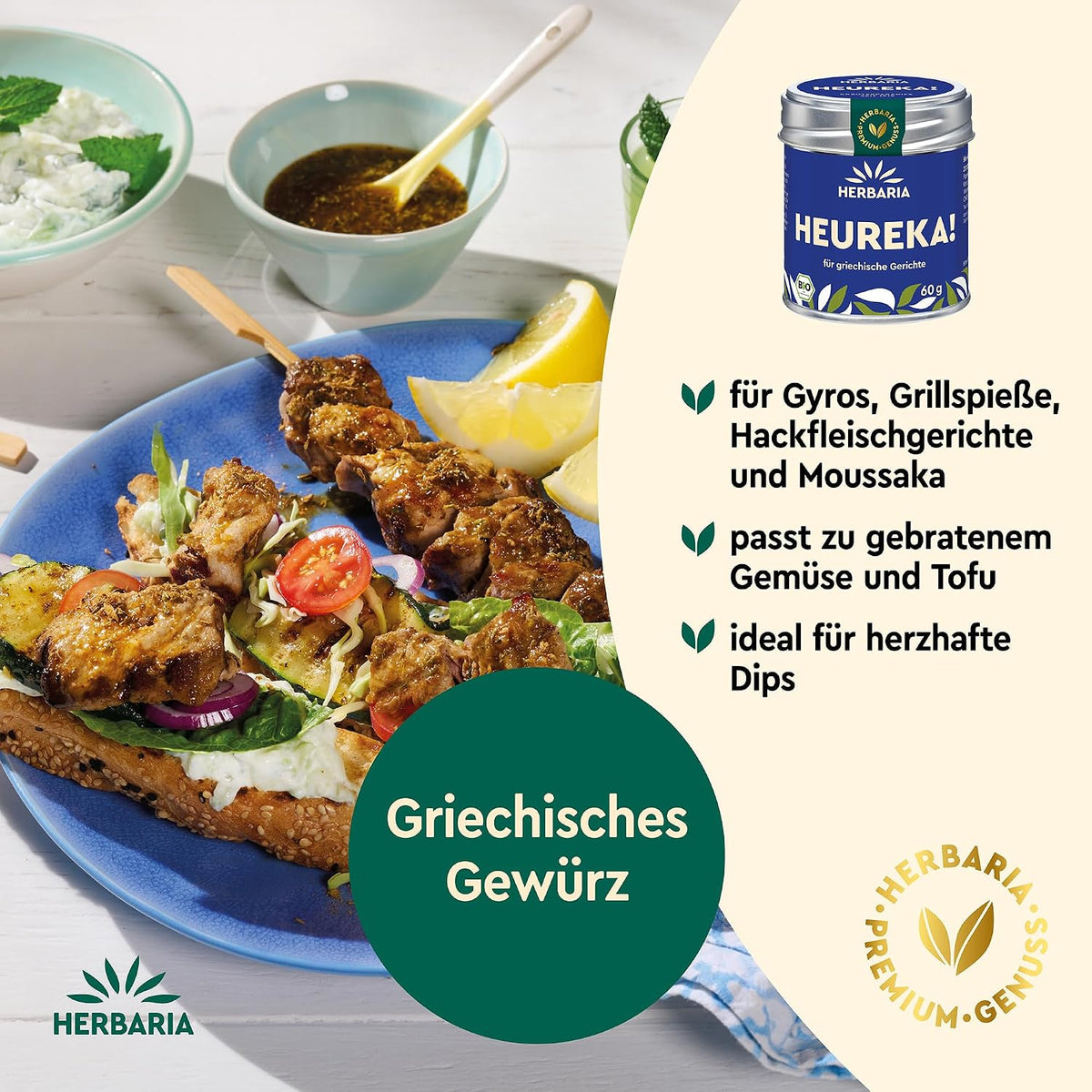 Griechische Speisen auf einem Teller mit Gyros und Dip, daneben die Herbaria Heureka Gewürzmischung Dose abgebildet.