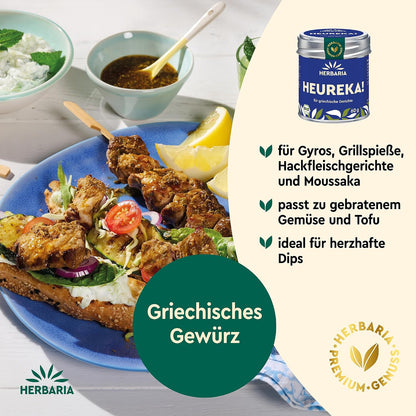 Griechische Speisen auf einem Teller mit Gyros und Dip, daneben die Herbaria Heureka Gewürzmischung Dose abgebildet.