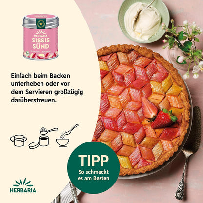 Rhabarberkuchen auf einem Teller, daneben Herbaria Sissis Sünd Dose und Serviervorschlag zum Backen oder Bestreuen, oben Schale mit Sahne.