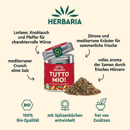 Herbaria Tutto Mio Dose mit geöffnetem Deckel und Gewürzmischung davor, umgeben von Zutatenhinweisen wie Lorbeer, Knoblauch und mediterrane Kräuter.