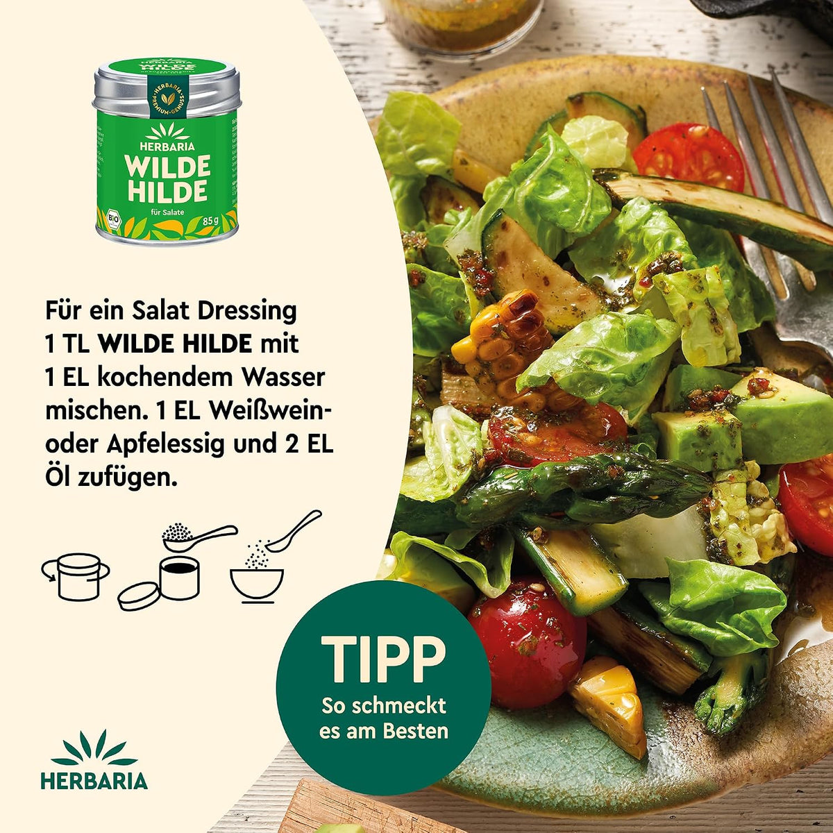 Teller mit gemischtem Salat, Avocado, Tomaten und Mais, daneben Herbaria Wilde Hilde Dose und Zubereitungstipp für Salatdressing.
