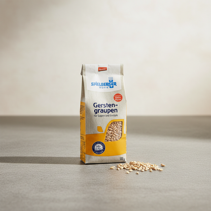 Small 500g organic barley packet on stone countertop with spilled grains, showcasing eco-friendly packaging and wholesome appeal.